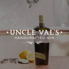 Une bouteille de gin est posée sur une table, entourée de citron, de concombre et de lavande. Texte : "UNCLE VAL'S HANDCRAFTED GIN".