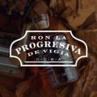 A rum bottle lies on spread-out tobacco leaves, surrounded by cigar tools.