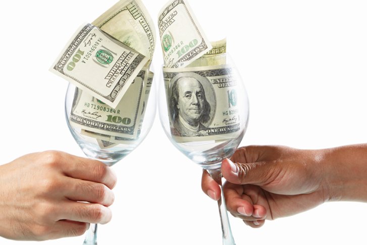 Zwei Weingläser, gefüllt mit Geldscheinen, stoßen auf weißem Hintergrund an.