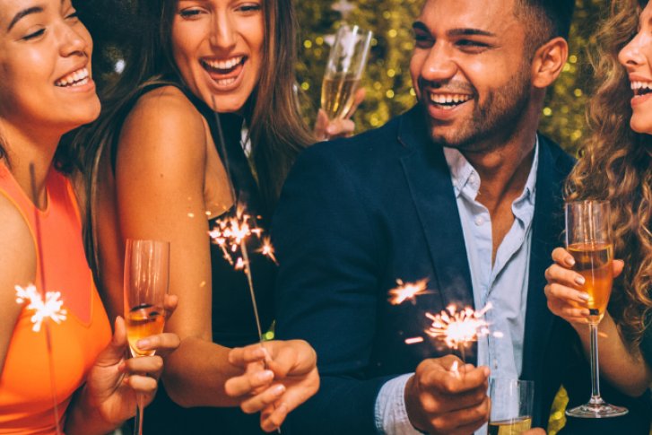 Bild zeigt Freunde zu Weihnachten mit Sekt und Sprühkerzen