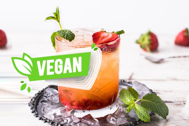 Getränk steht auf Eis, dekoriert mit Erdbeeren und Minze; Text: "VEGAN".
