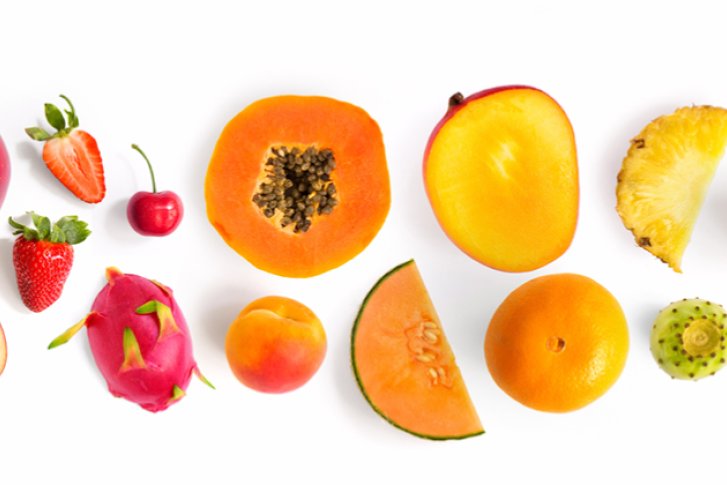 Diverse Früchte liegen nebeneinander auf weißem Hintergrund, bilden eine bunte, abwechslungsreiche Reihe.