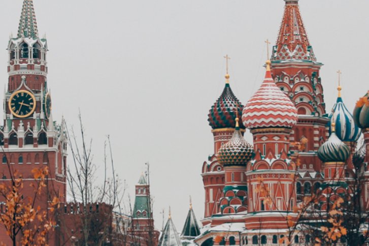 Historische Kathedrale steht still im Schneewinter umgeben von kahlen Bäumen und grauem Himmel.