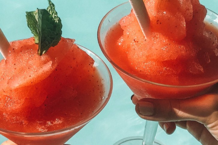 Hände halten ein Sorbet in intensiver roter Farbe