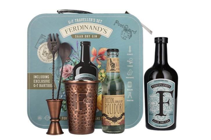 Gin-Set enthält Flasche, Kupferbecher, Tonic-Flasche vor illustrierter Verpackung mit Blumenmotiven.