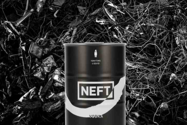 Ein schwarzes NEFT-Wodka-Fass steht vor einem dunklen, verworrenen Hintergrund aus Ästen.