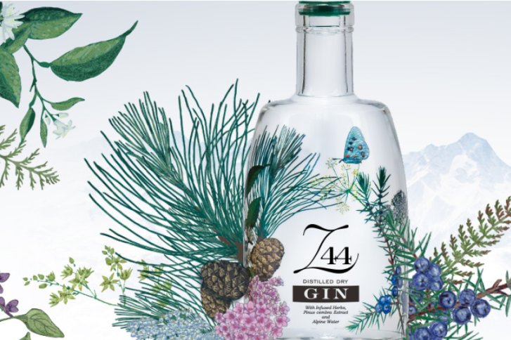 Gin-Flasche steht umgeben von alpinen Pflanzen, Bergen im Hintergrund, Etikett zeigt "Z44 Gin".