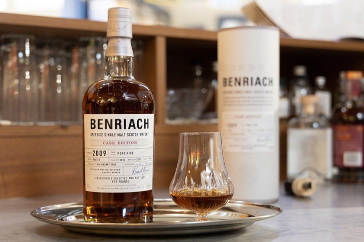 Flasche Benriach Whisky steht neben gefülltem Glas auf Tablett, umgeben von Barzubehör.