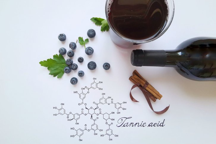 Weinflasche, Glas, Blaubeeren und Zimt liegen neben chemischer Strukturformel von Tanningerbsäure.
