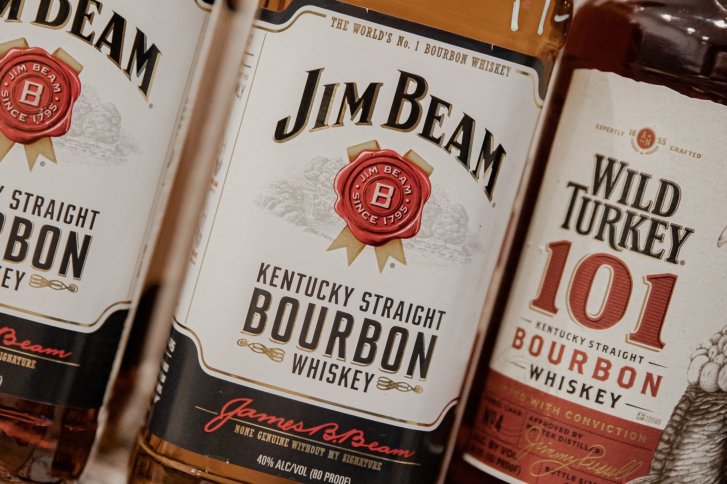 Whiskeyflaschen stehen nebeneinander, zeigen Etiketten mit "Jim Beam" und "Wild Turkey 101".