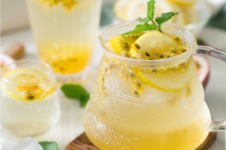 Ein Krug mit zitronig-gelbem Getränk steht auf einem Tisch, dekoriert mit Minze.