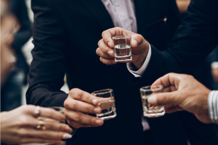 Gläser – werden gehoben – von Menschen in formeller Kleidung bei einer Feier.