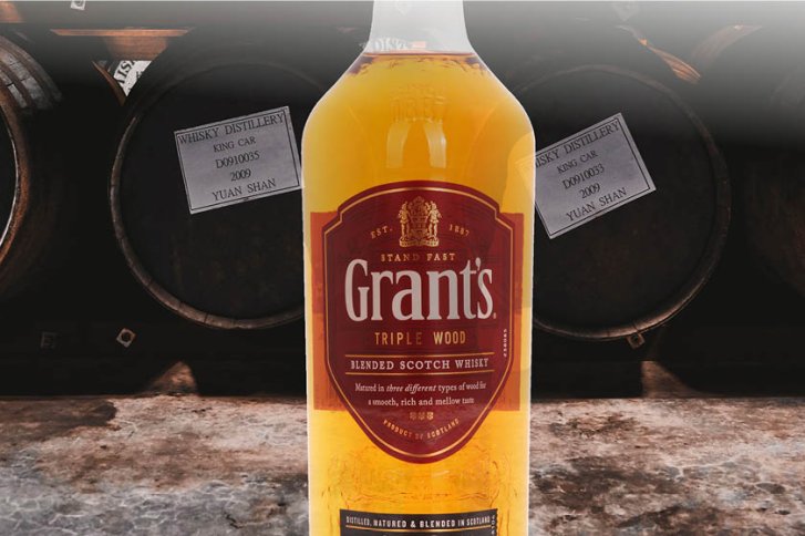 Flasche Grant's Whisky steht vor Whiskyfässern, Etiketten mit "Whisky Distillery King Car 2009".