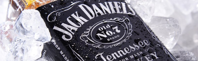 Bottle of Jack Daniel's, lying in the ice, covered with drops of water, label clearly recognizable.