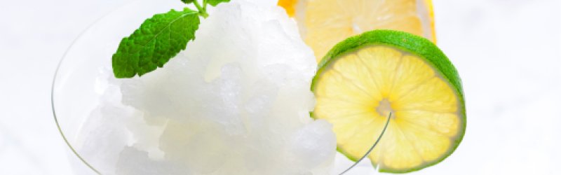 Bild zeigt ein Caipirinha Sorbet mit Limette und Eis im Glas.