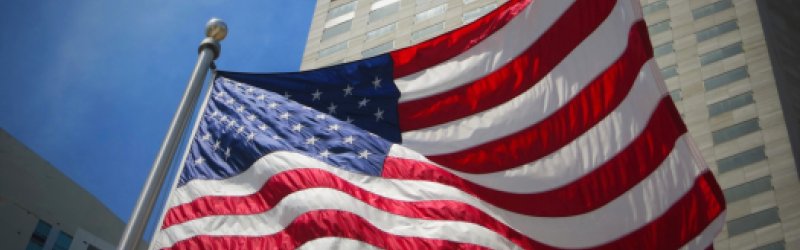 Amerikanische Flagge mit hohem Gebäude im Hintergrund