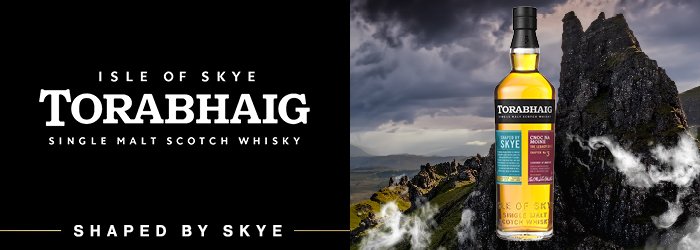 Whiskyflasche steht vor schottischer Berglandschaft, dunkle Wolken am Himmel, Text links: "TORABHAIG".