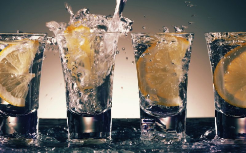 L'image montre une collection de verres remplis de différentes boissons alcoolisées. Ce présentoir montre une série de récipients à boire, dont des verres à pied et des verres highball, qui sont généralement utilisés pour servir des cocktails classiques et des boissons alcoolisées.